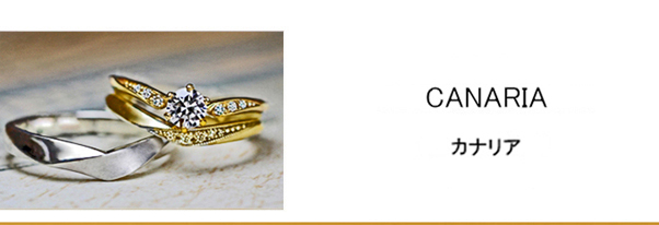 指にとまったカナリアのゴールドの婚約指輪と結婚指輪セットリング