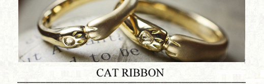 ネコの手でハグされているゴールドのオーダーメイド結婚指輪の画像