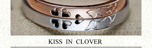 ピンク＆白のネコがクローバーでキスするオーダーメイドの結婚指輪の画像
