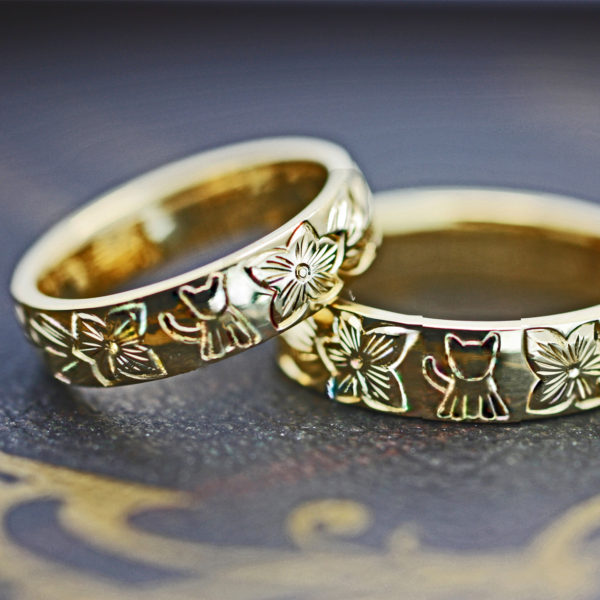 ハワイアン模様にネコがデザインされたゴールドのオーダー結婚指輪