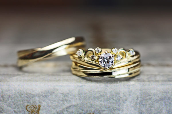 ティアラデザインのゴールド婚約指輪とクロスしたデザインの結婚指輪の3本セット