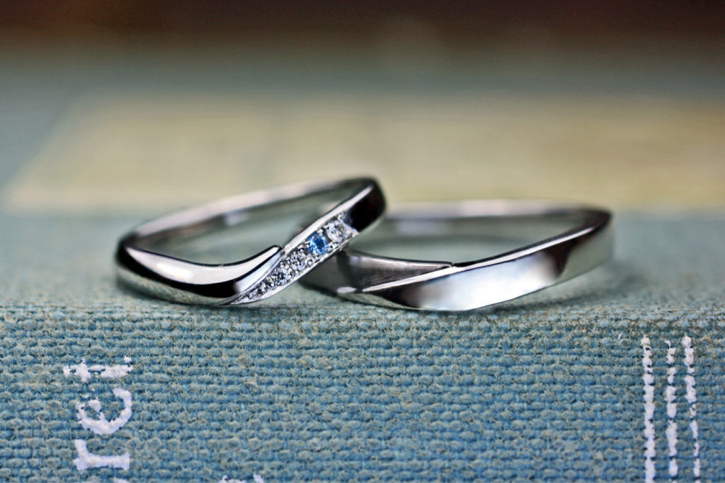 ダイヤが並んでだ中にブルーの石がある結婚指輪