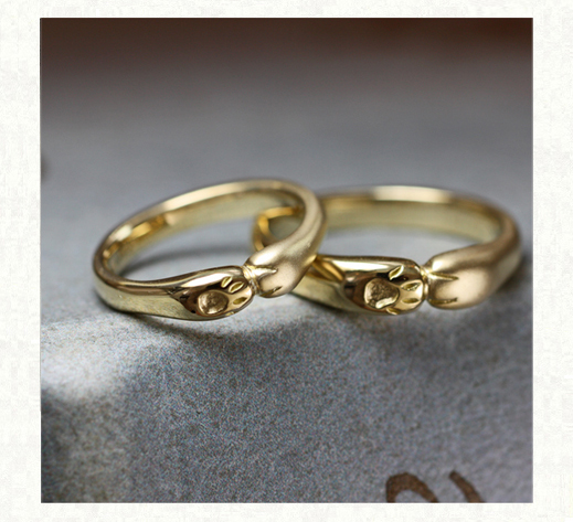ネコが薬指にハグしているようなデザインの結婚指輪
