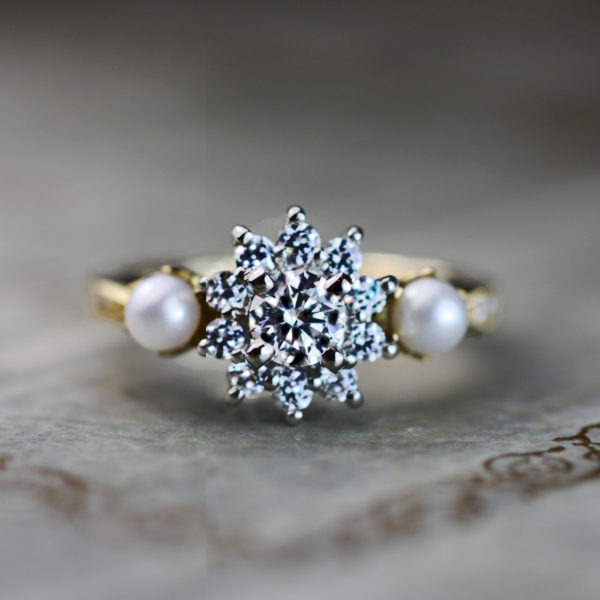 輝くダイヤモンドの星の周りを２つの真珠が寄り添うオーダー婚約指輪