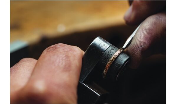 金細工職人はタガネを使って結婚指輪に柄や模様を入れる