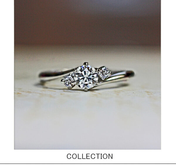 センターダイヤモンドの両サイドにメレーダイヤモンドをセットした太陽モチーフの婚約指輪 