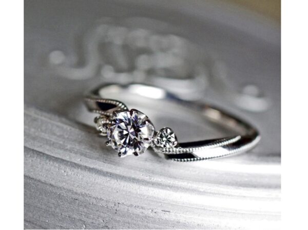 【リボン】をひねったデザインにミルグレインをあしらった婚約指輪作品 