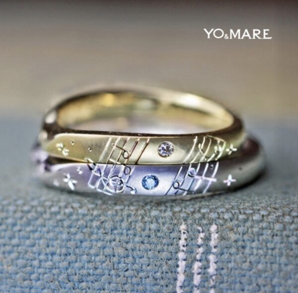 クラッシックの楽譜を入れたゴールドとプラチナの結婚指輪 ＞